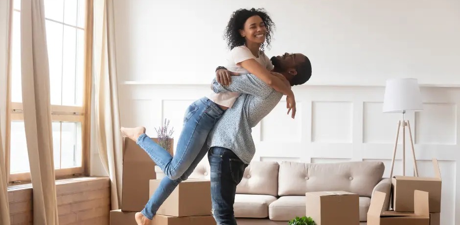 A couple celebrating among moving boxes in their new home
