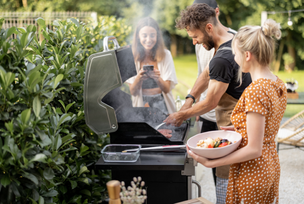 Friends cooking on a barbecue in a garden