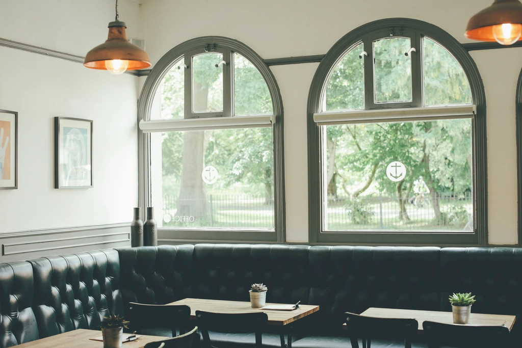 Empty cafe interior with arched windows looking onto trees
