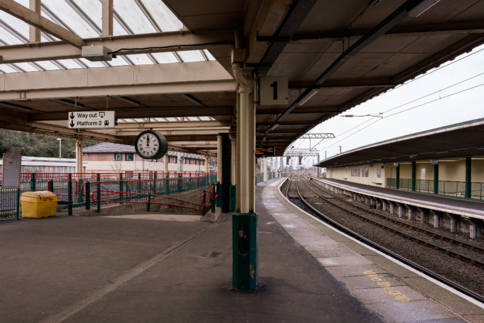 An empty railway station platform with a Way Out sign